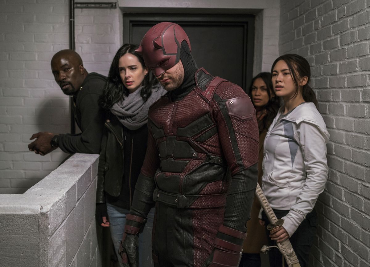 Luke Cage, jessica Jones, Daredevil, and Colleen Wing stand in the hallway in The Defenders